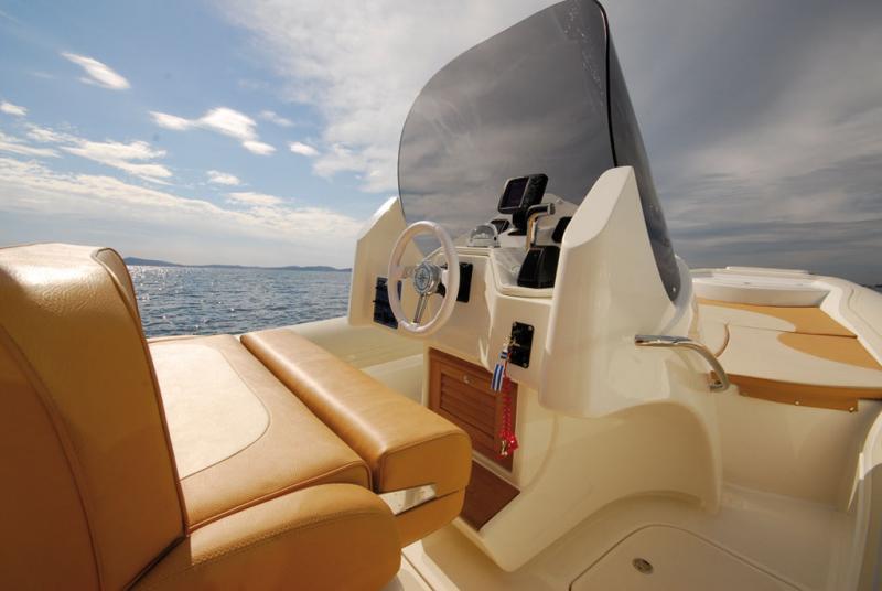 Banquette de pilotage confortable, assise relevable pour le pilotage debout et avec cale-pied en teck pour le pilotage assis.