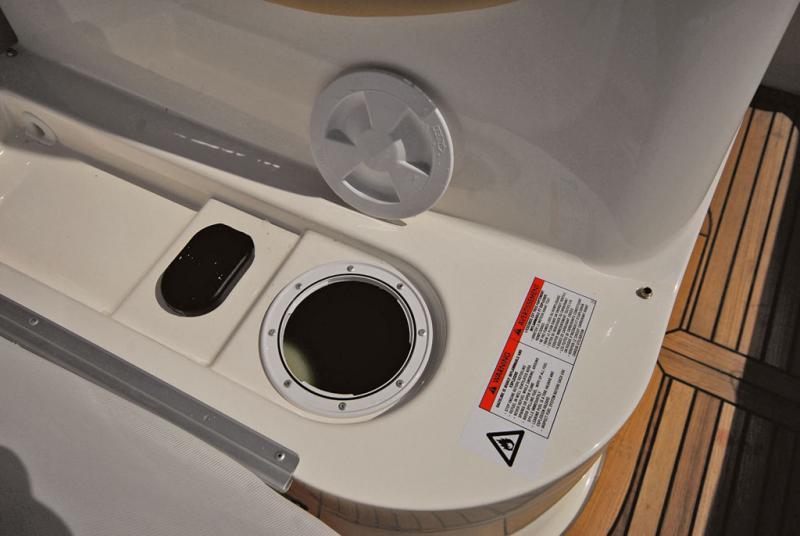 Sous le siège console : nable de remplissage du réservoir, avec cuvette d'évacuation en cas de débordement, et trappe d'accès à la jauge.