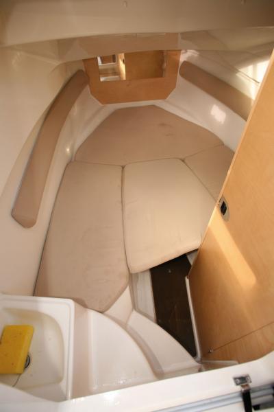 Au centre, la planche qui supporte le coussin complémentaire, permettant de convertir la couchette en V en couchage double, se transforme en dînette grâce à un pied-colonne (non disponible lors de notre essai).
