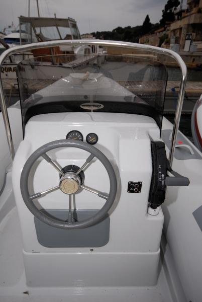 Console de pilotage avec pare-brise efficace, poignée de gaz bien placée, et de la place pour installer l’écran sondeur GPS.Mais,en pilotage assis, on ne voit pas les cadrans derrière le volant.
