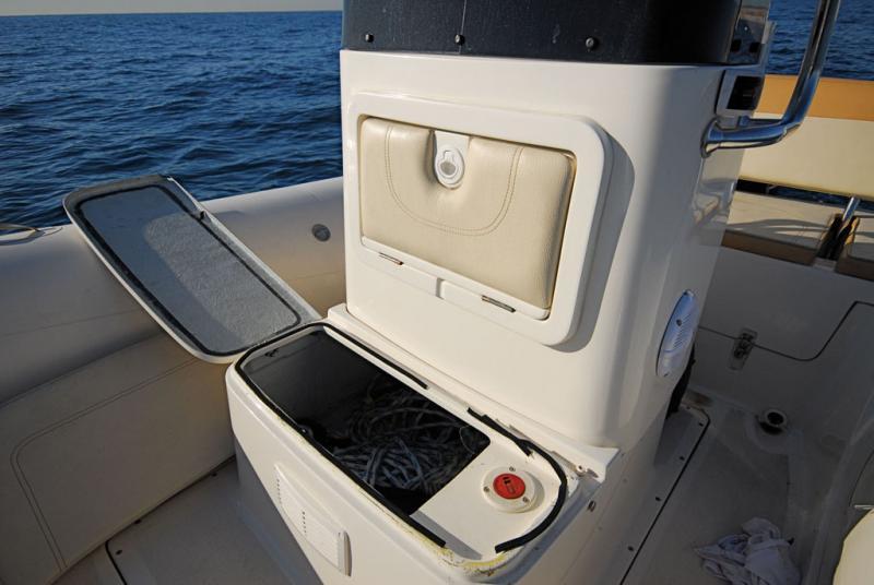 Deux rangements pratiques dans la console (le dossier/capot ouvre celui du haut), mais un nable de réservoir d’essence mal placé. 
