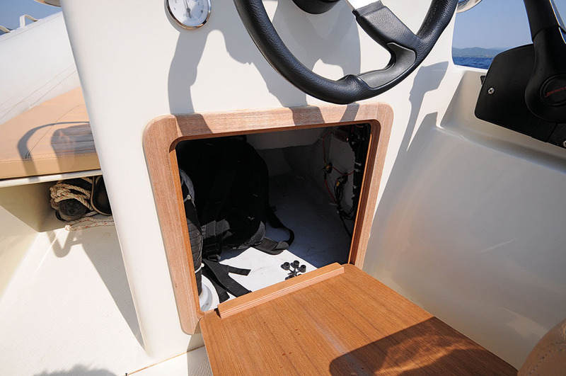 Fermé par un large panneau amovible en teck, le placard sous la console offre un rangement utile et d'accès aisé.