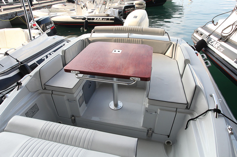 Superbe carré de poupe que celui du 65 Suite ! La table en acajou verni fait également office d'extension de bain de soleil une fois ôté le pied colonne en inox. 