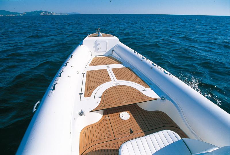 Très chic ce pont paré de teck ! Bien vu, l’élément en demi-lune du bain de soleil convertible en table.
