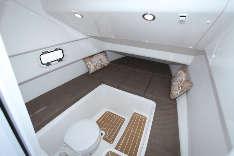 La cabine possède une belle hauteur à l'entrée. Le complément de couchette viendra couvrir le WC. Un petit lavabo, qui propose un robinet avec flexible pour la douche, se cache sous le coussin à bâbord.