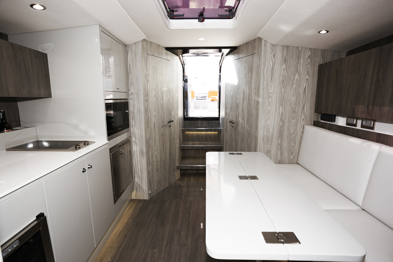 La kitchenette extérieure n’empêche pas la présence d’une belle cuisine intérieure faisant face au carré. Au fond, la cabine propriétaire…

