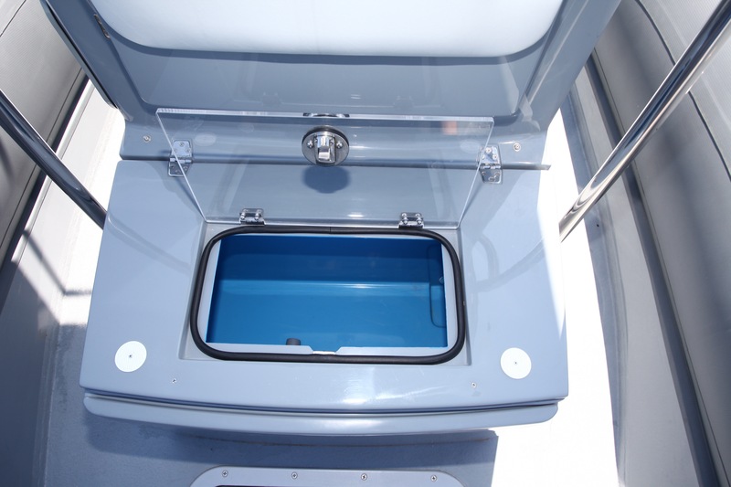 Sous l’assise du siège devant la console, le couvercle du second vivier, lui aussi alimenté en eau de mer par une pompe. 