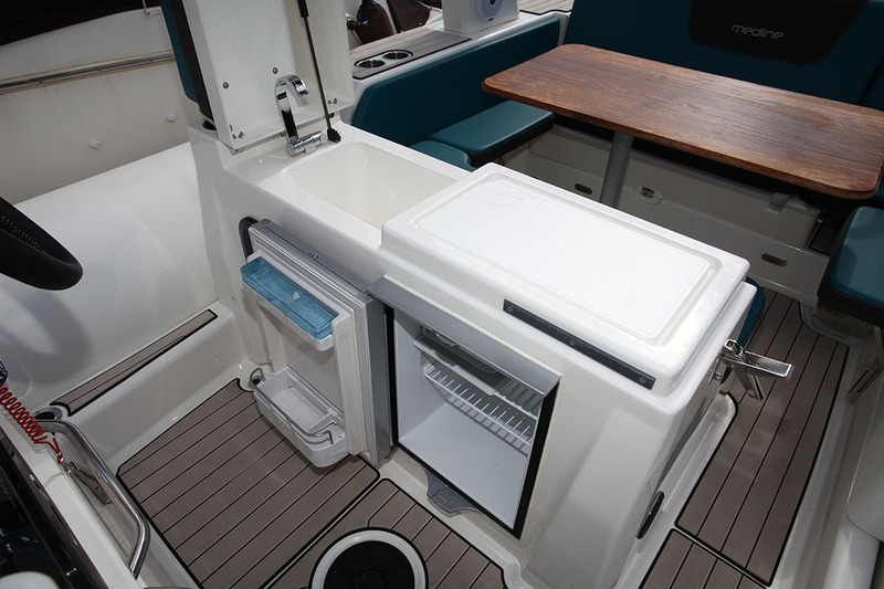 La kitchenette est située sous l’assise de pilotage. Au menu, un frigo, un évier et un beau plan de travail. Un réchaud est aussi proposé…