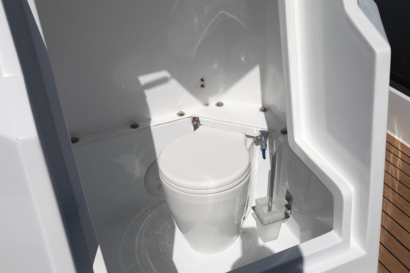 La console est suffisamment haute pour abriter un WC marin. Ce dernier est facilement accessible grâce à l’ample ouverture assistée par vérins à gaz.

