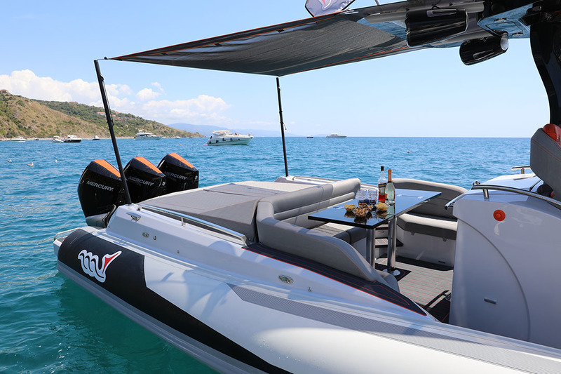 Tout l’agrément du grand carré avec sa belle table en bois laqué noir, pour déjeuner à l’ombre du bimini. Le solarium et le bloc-cuisine ne sont pas loin…

