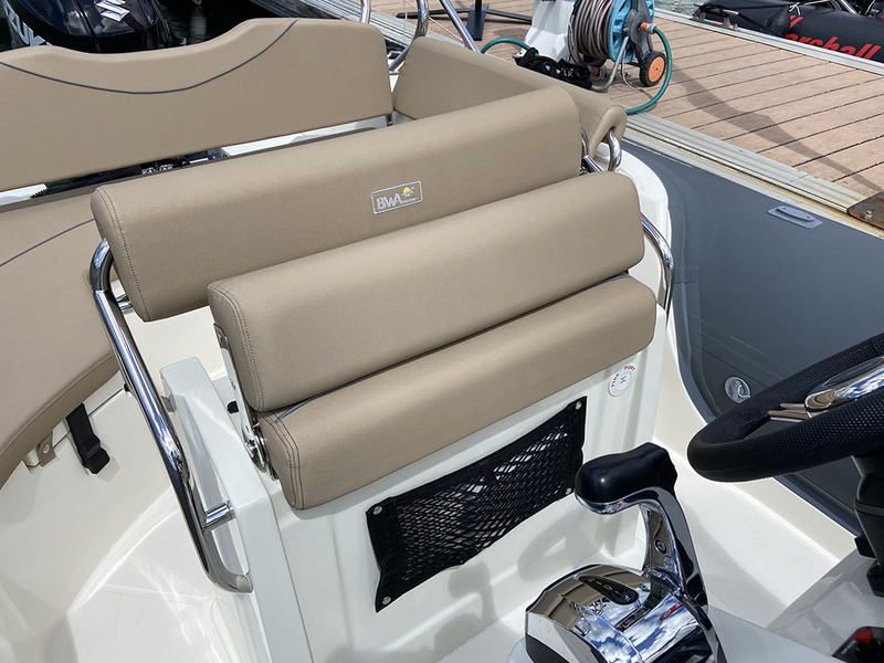 La demi-assise articulée du siège de pilotage permet de barrer debout ou assis en fonction des conditions de mer. Bien vu, le petit filet vide-poches ! 